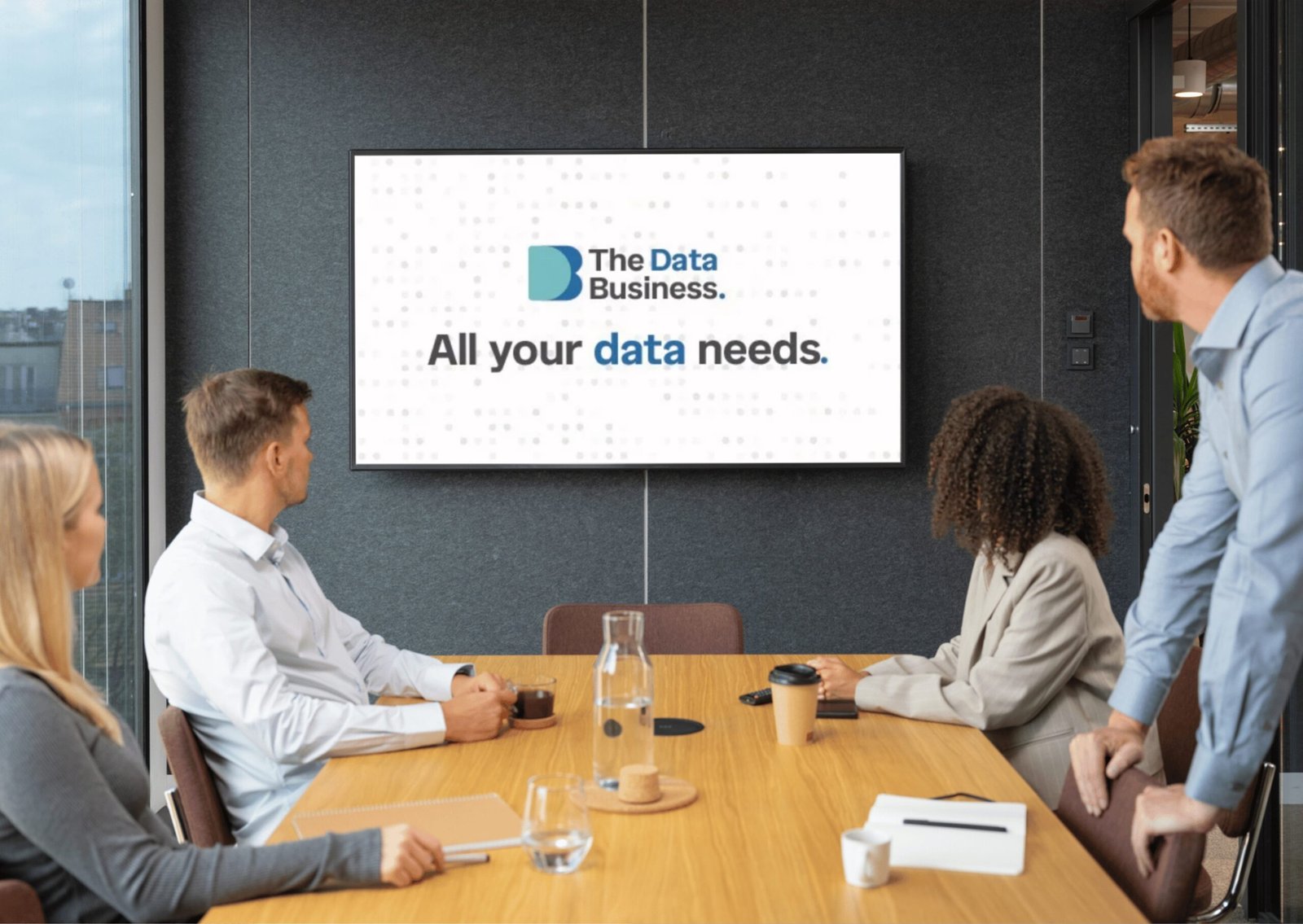 The Data Business identity on a boardroom screen — “All your data needs.”